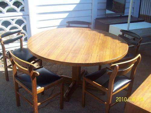 Round veneer kiaat table with 5 black leather chairs. table 1.3 m diameter