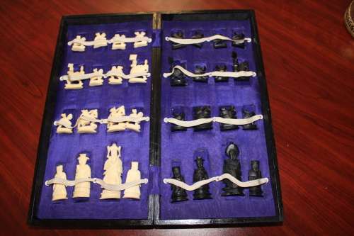 ANTIQUE CHINESE HANDCARVED and STAINED BONE CHESS SET WITH LACQUERED WOODEN BOARD/CASE 34 BY 35 CM