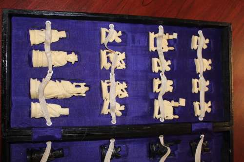 ANTIQUE CHINESE HANDCARVED and STAINED BONE CHESS SET WITH LACQUERED WOODEN BOARD/CASE 34 BY 35 CM