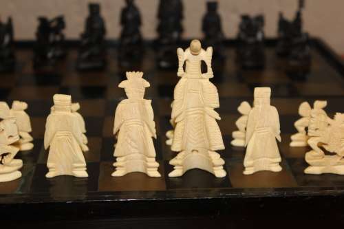 ANTIQUE CHINESE HANDCARVED and STAINED BONE CHESS SET WITH LACQUERED WOODEN BOARD/CASE 34 BY 35 CM