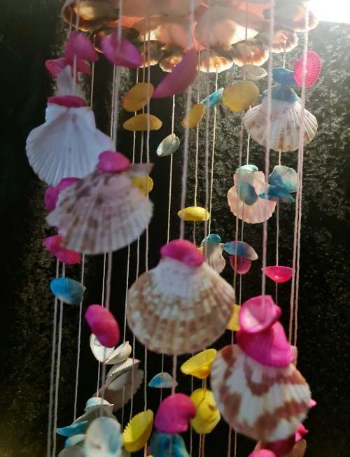 Fun and flirty. Pink, blue and yellow shell windchime