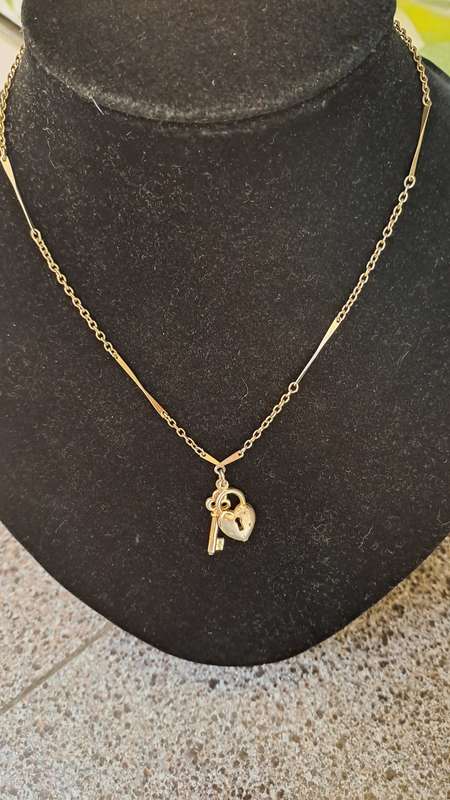 Gold toned necklace with heart and key