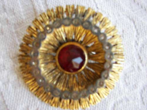 VINTAGE ROUND GOLD COLOURED BROOCH/PIN WITH LARGE RED STONE AND SMALL FAUX DIAMANTES