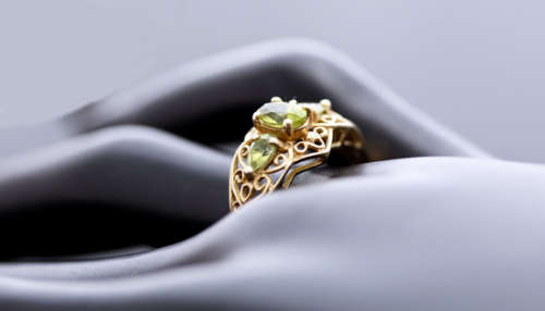 UNUSUAL VINTAGE PERIDOT 9CT YELLOW GOLD RING WITH OPENWORK SCROLL DETAILS. 375