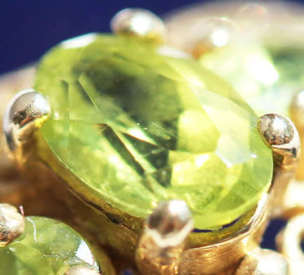 UNUSUAL VINTAGE PERIDOT 9CT YELLOW GOLD RING WITH OPENWORK SCROLL DETAILS. 375