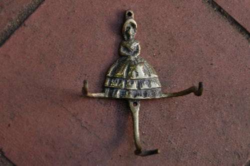 Old fashioned lady brass triple hook ? used to hold a Table Tidy ?