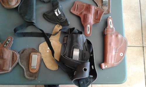 COLLECTION OF 28 PISTOL/ REVOLVER HOLSTERS. WIDE ASSORTMENT. ONE BID..