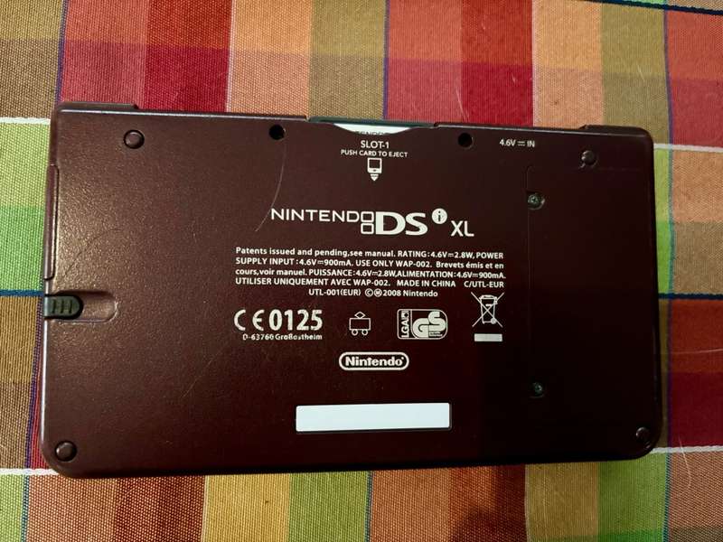 burgundy Nintendo DSi XL with charger