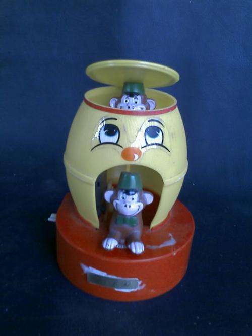 MONEY GRABBING MONEYS IN BARREL. WIND-UP. PLACE COIN ON MARK AND MONKEY TAKES IT.