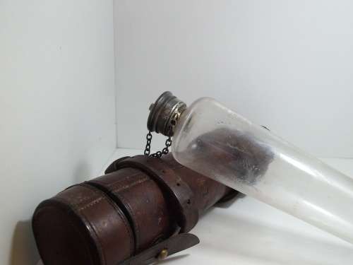 Antique saddle flask glass with leather holder.