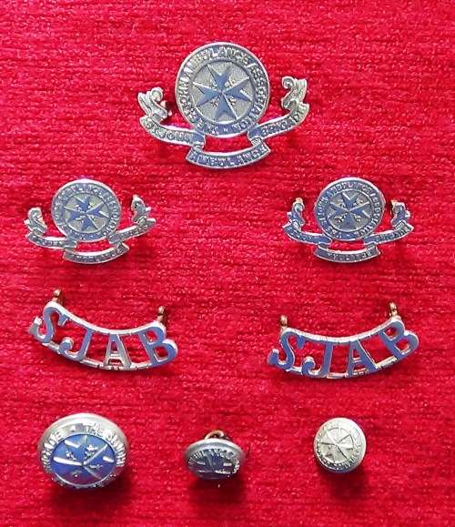 Complete set of St. Johns Ambulance insignia with three different sizes of buttons.