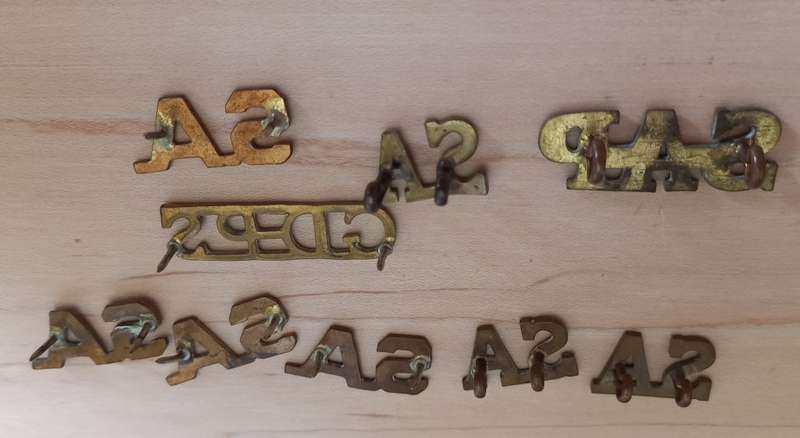 Assorted South African Brass Titles lugs intact