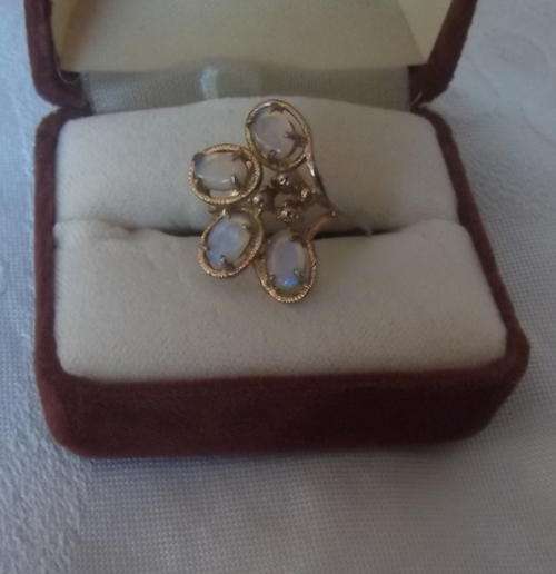 FOUR LOVELY OPALS SET IN A GILDED COSTUME RING