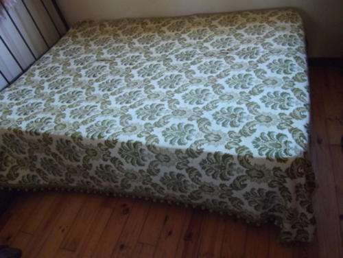A STUNNING VINTAGE GREEN AND GOLD TASSELED BEDSREAD