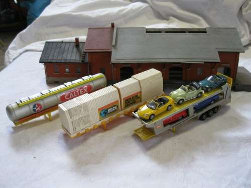 HO RAILWAY MODEL  STATION BUILDING, 3 TRAILERS, ONE VEHICLE TRANSPORTER WITH 5 CARS