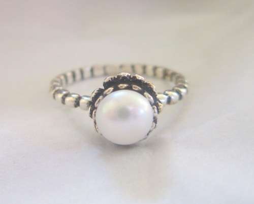 Genuine pearl set in a delightful sterling silver flower crown ring.