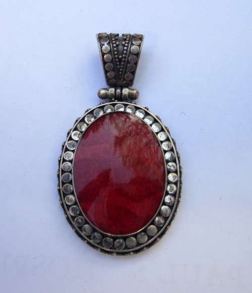 Red coral set in a beautifully decorative sterling silver hinged pendant.