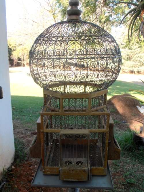 A very ornate and decorative wooden and metal bird cage, canary, finch, budgie