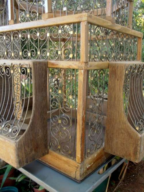 A very ornate and decorative wooden and metal bird cage, canary, finch, budgie