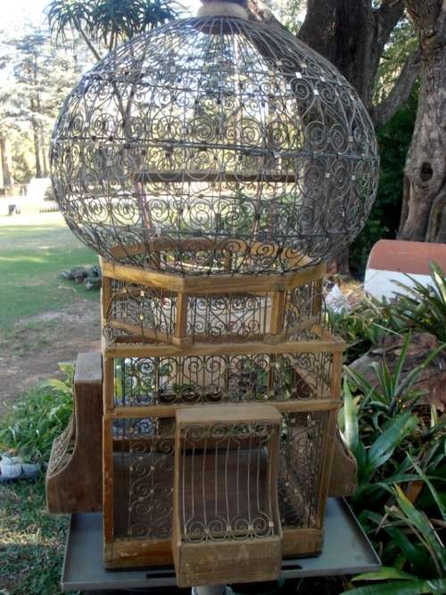 A very ornate and decorative wooden and metal bird cage, canary, finch, budgie