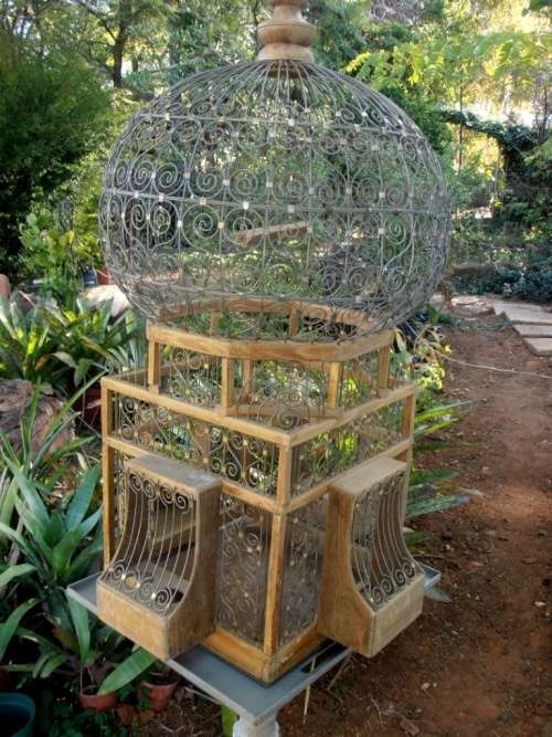 A very ornate and decorative wooden and metal bird cage, canary, finch, budgie