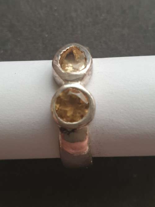 A siver ring with pink stons one rond and one teardrop the ring is stamp 925