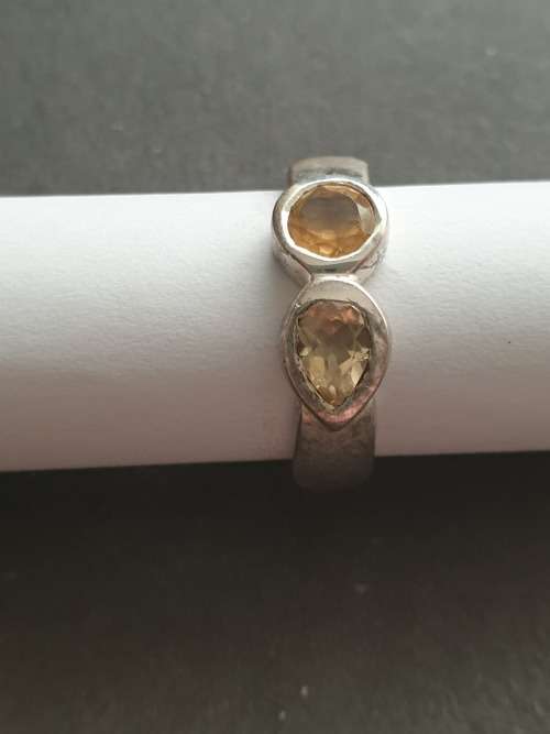 A siver ring with pink stons one rond and one teardrop the ring is stamp 925