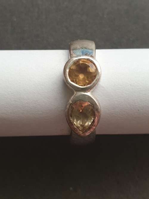 A siver ring with pink stons one rond and one teardrop the ring is stamp 925