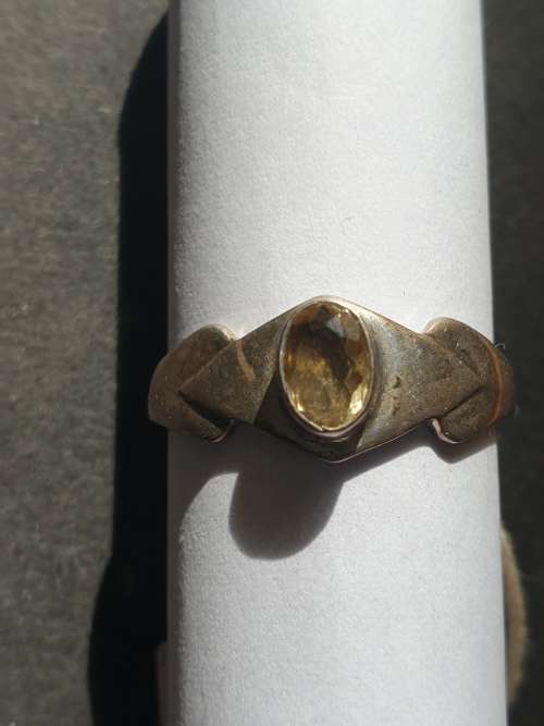 A siver ring with yellow stones cushion cut stone