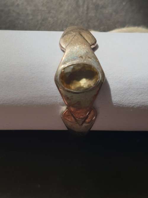 A siver ring with yellow stones cushion cut stone
