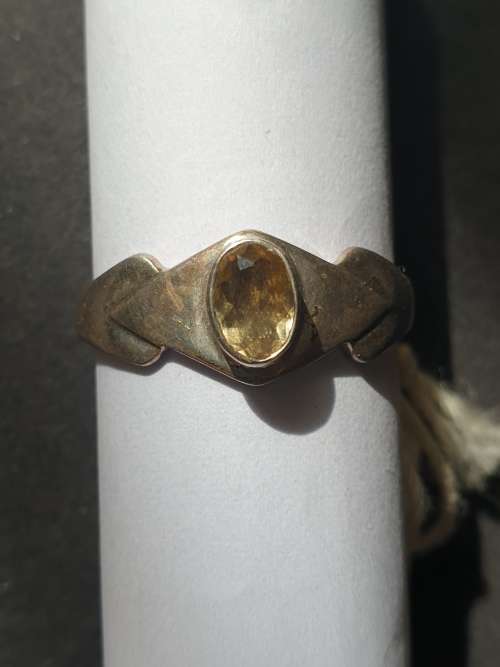 A siver ring with yellow stones cushion cut stone