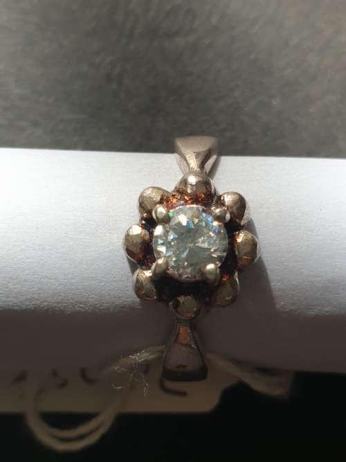 A siver ring with white stones round cut stone