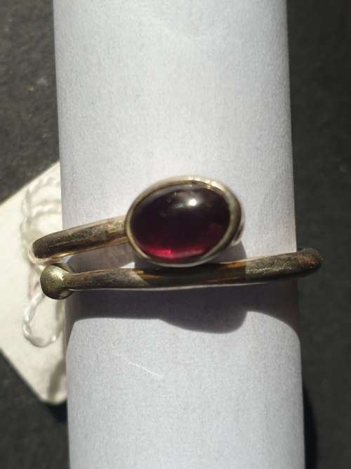 A siver ring with red stones ovel cut stone