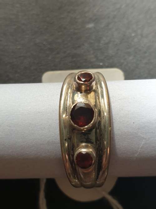 A sliver ring with 3 red stones rowed cut stone stamped 925