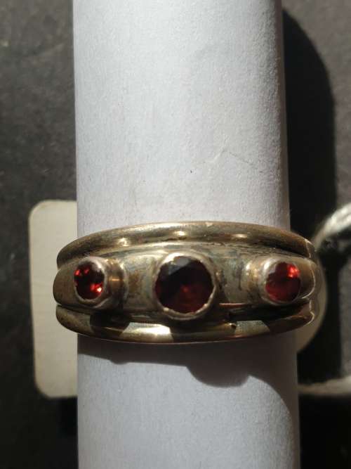 A sliver ring with 3 red stones rowed cut stone stamped 925