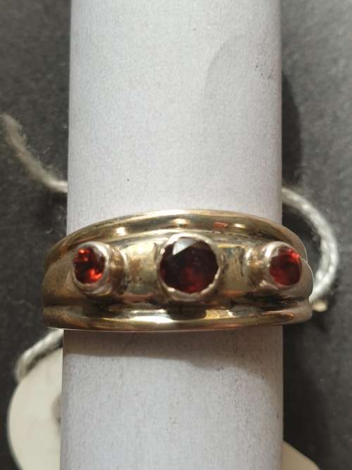 A sliver ring with 3 red stones rowed cut stone stamped 925