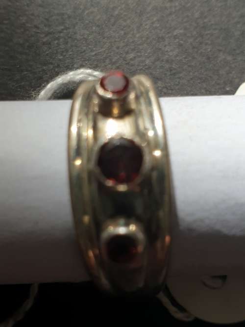 A sliver ring with 3 red stones rowed cut stone stamped 925
