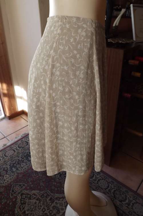 Cute beige with thin white flower pattern lined skater skirt.size 32/8.Sheer polyester fabric