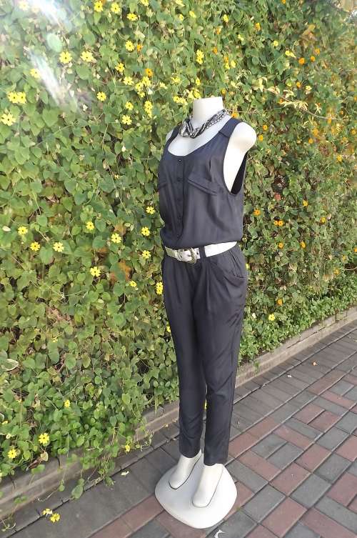 Black sleeveless jumpsuit in silky poly/rayon blend.Size 32/8 skinny legs.Elasticated in middle