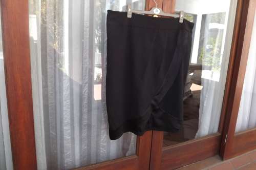 Upstyle black polyester stretch skirt.Cross over front with rounded seams.Size 40/16 by Donna-Claire