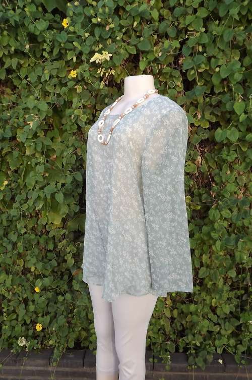 Cool sheer moss green long sleeve top with tiny beige floral pattern.Rounded neckline.Size 38/14.
