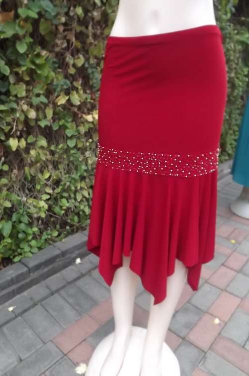 Irresistible red stretch poly embellished skirt.Size 34/36.Pencil skirt with pointed high/low seam