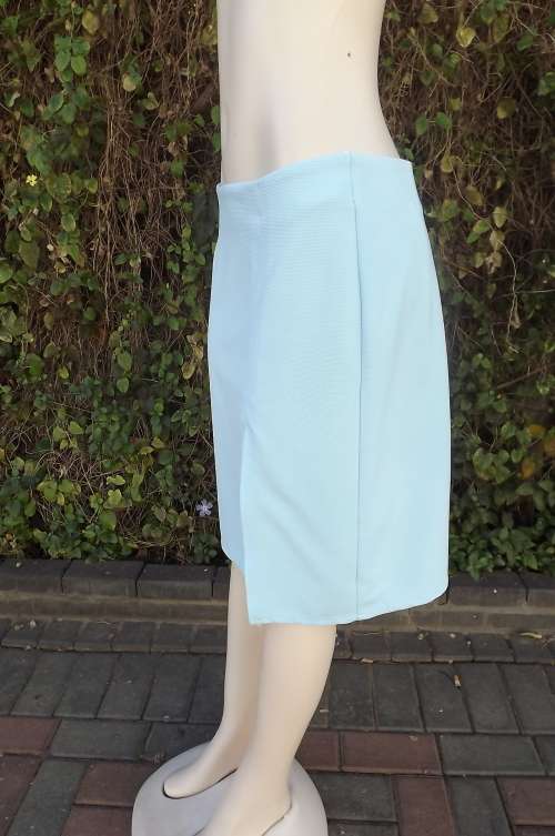 Sky blue ribbed stretch polyester knee length skirt.Size 38/14.Bandless.Slit in seam on left front