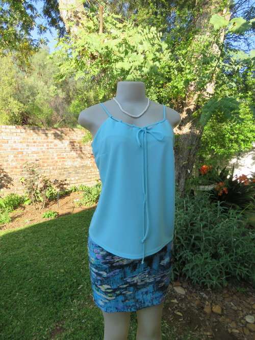 Skyblue summer top by TOPICS in size 37/13.Unique strappy neckline.As new.In stretch polyester
