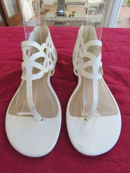Pair of white roman style sandals in white by FOSHINI in size 5.Good condition.