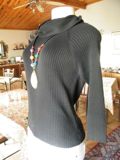 Black ribbed pattern knitted poloneck top with long sleeves.Acrylic knit.Size 34/10.Used a lot