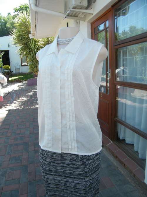 Beautiful white patterned polyester satin top..Size 36/12.Sleeveless with tucked fronts.New top