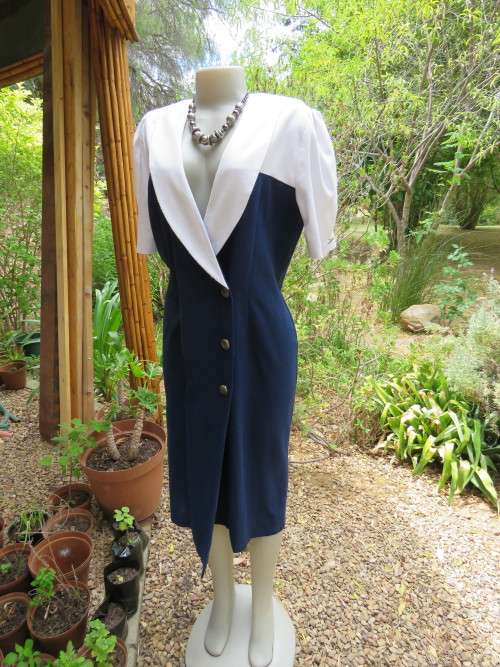 Classic navy fold over dress closing with 6 buttons on top.Size 40/16 with white collar.