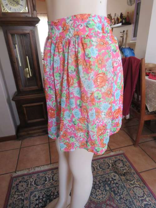 Cute mini skirt in pink floral pattern with band in middle.Elasticated at back.Size 32/8