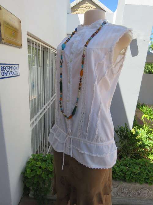 Cream cotton top with button down front.Sleeveless with high collar.Size 38/14.Laced back yoke